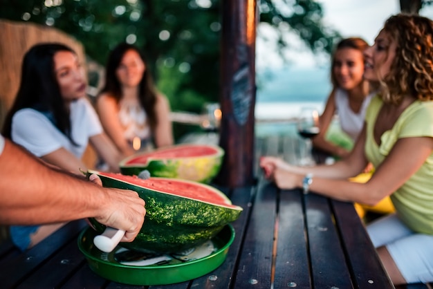 Spaß haben und Scheiben Wassermelone essen.