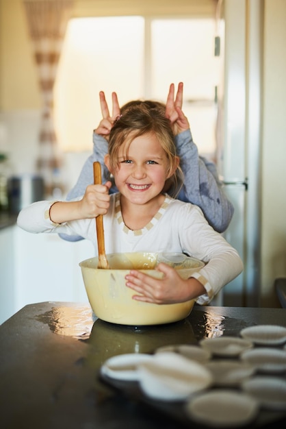 Spaß mit Erinnerungen vermischen Schnappschuss von zwei jungen Geschwistern, die sich beim gemeinsamen Backen zu Hause vergnügen