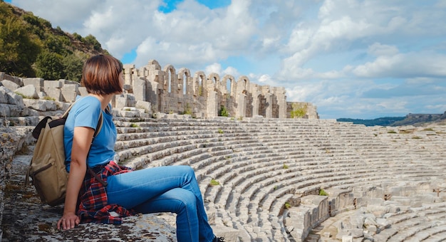 Spaziergang in Antalya, Türkei, an einem warmen Oktobernachmittag Schöne Touristin mit Rucksack bei den Ruinen der antiken Stadt Perge