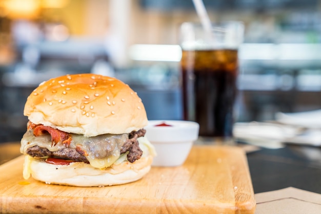 Speckkäseburger mit Rindfleisch auf hölzernem Brett im Restaurant