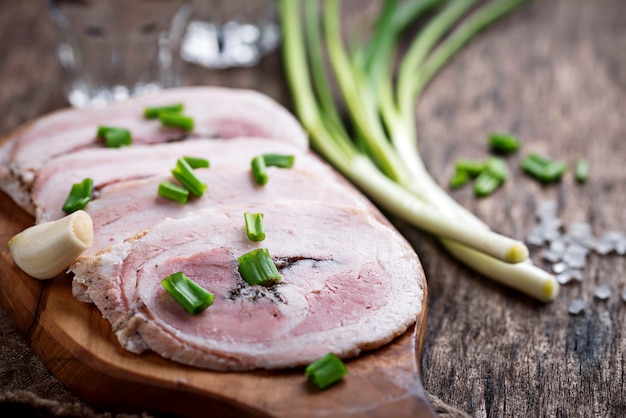 Foto speckscheiben mit frühlingszwiebel und knoblauch