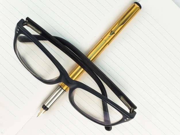 Specs und Golden Pen auf der Zeitschrift oder Notizbuch