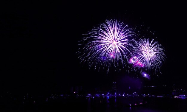 Spektakuläre blau- und rosa gefärbte Feuerwerke explodieren in den Nachthimmel