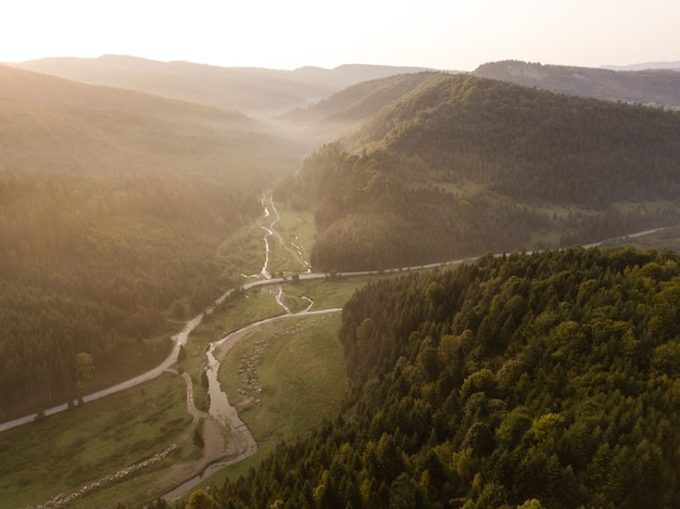 Spektakuläre Luftaufnahme zur Straße mit Bergen, die bei Sonnenaufgang von oben aufgenommen wurden, Karpatenberge