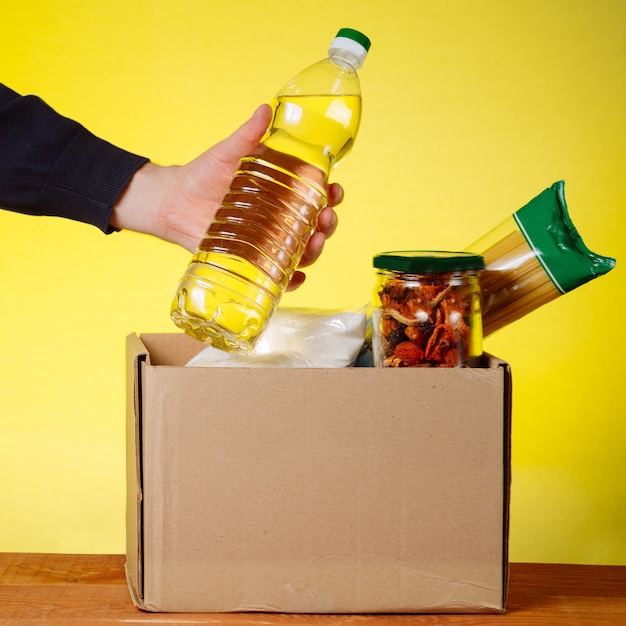 Foto spendenbox mit essen. und hände eines freiwilligen