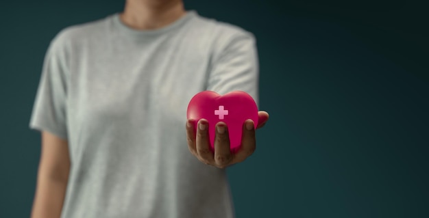 Foto spendenkonzept-hand, die eine herzform mit kreuz gibt und dabei hilft, unterstützung und zusammengehörigkeit zu leisten