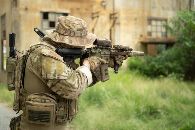 Foto speziale streitkräfte soldat in tarnung mit einem paar waffen, die voller moderner technologie sind.