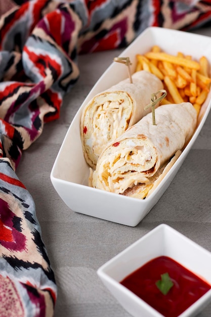 Spezieller Shawarma-Wrap mit Pommes, serviert in einem Gericht, das auf dem Tisch mit Blick auf arabisches Essen isoliert ist