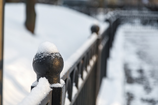 Sphärische Spitze des dekorativen Metallzauns im Schnee.