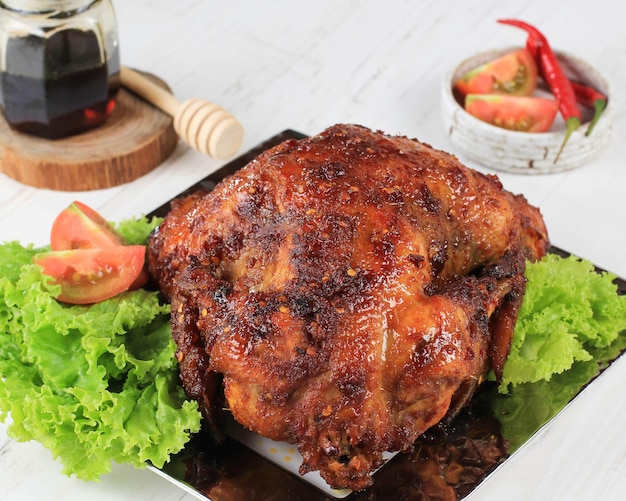 Spicy Honey Roasted Whole Chicken Typisches indonesisches Essen namens Ayam Bakar Bumbu Rujak