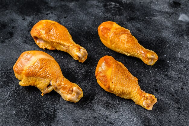 Spicy Smoked Chicken Leg Drumsticks auf einem Küchentisch auf schwarzem Tisch. Draufsicht.