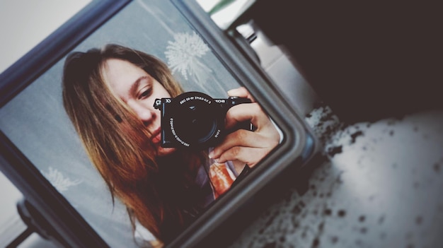 Spiegelbild einer fotografierenden Frau im Spiegel
