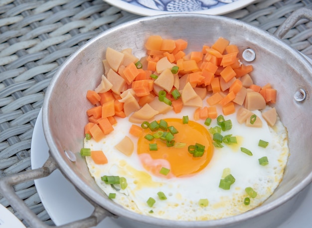 Spiegelei in Sojasauce mit Wurst und Karotten in der Pfanne