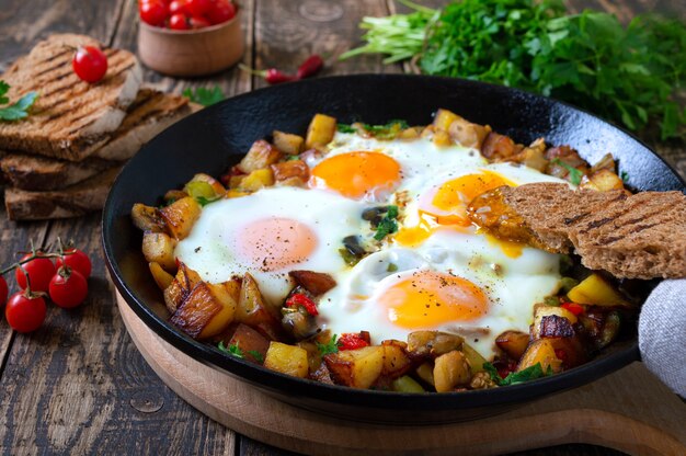 Spiegeleier mit Gemüse-Shakshuka in einer Pfanne und Roggenbrot