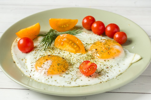 Spiegeleier mit Kirschtomaten auf einer Platte