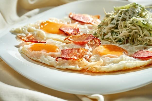 Spiegeleier mit Speck und Salat auf einem Teller Hartes Licht Selektiver Fokus Frühstück