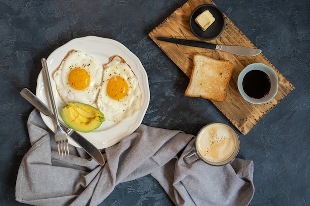 Foto spiegeleier mit toast-avocado-marmelade und kaffeebecher