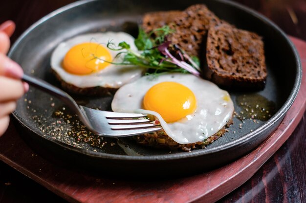 Spiegeleier probieren Eier und Tatar mit einer Gabel essen