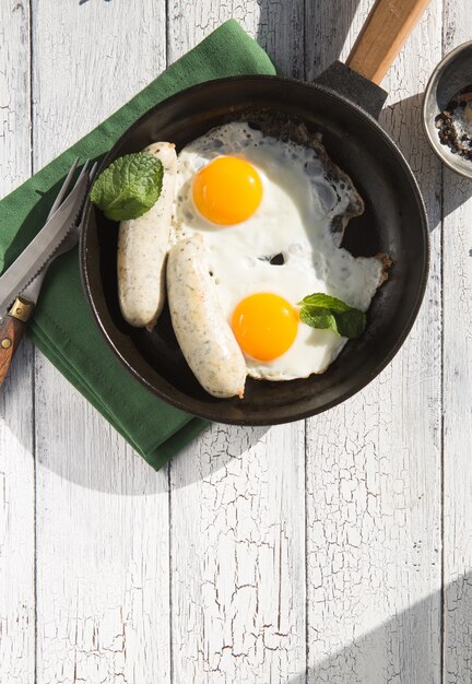 Spiegeleier, Wurst in der Eisenpfanne - Gesundes englisches Frühstück. Farbblock