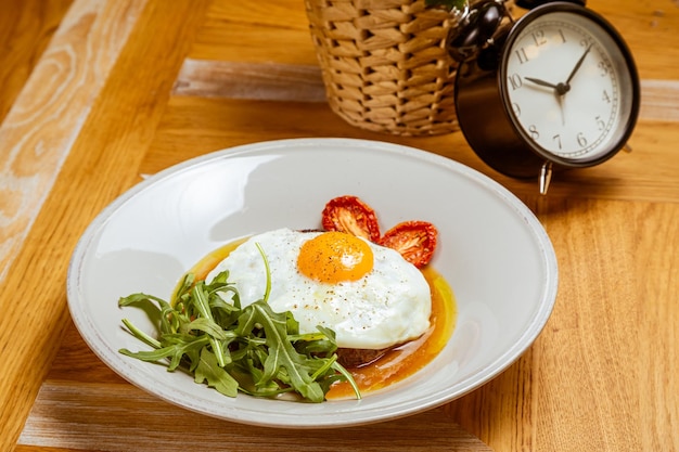 Foto spiegeleier zum frühstück mit beefsteak-rucola und sonnengetrockneten tomaten