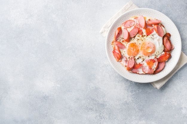 Spiegeleiwürste und -tomaten auf einer Platte auf dem Tisch.