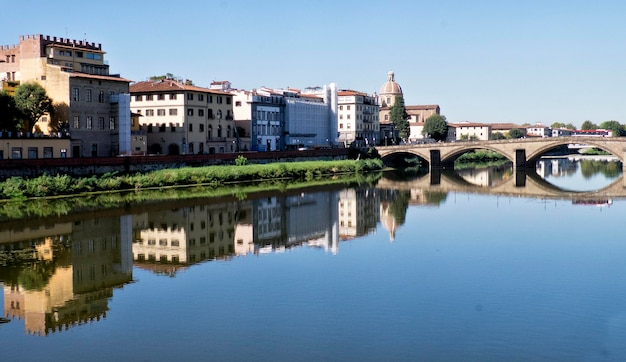 Spiegelung von Gebäuden und Brücken auf dem Fluss Arno gegen den Himmel