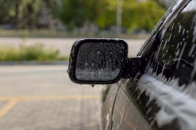 Spiegelwaschen im Auto mit Aktivschaum Autowäsche