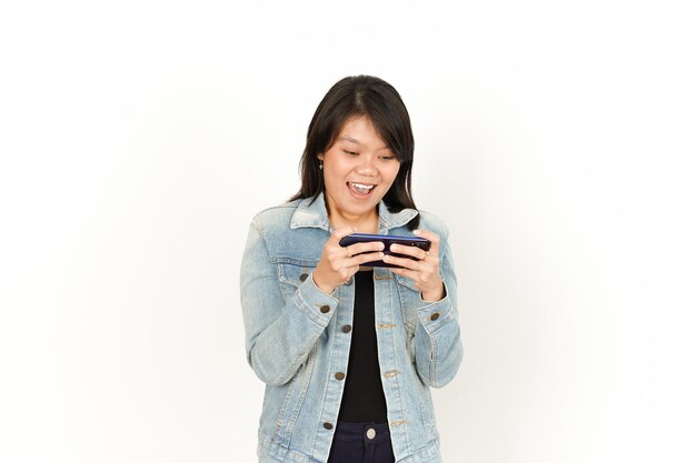 Spiel am Telefon mit glücklichem Gesicht der schönen asiatischen Frau mit Jeansjacke und schwarzem Hemd spielen