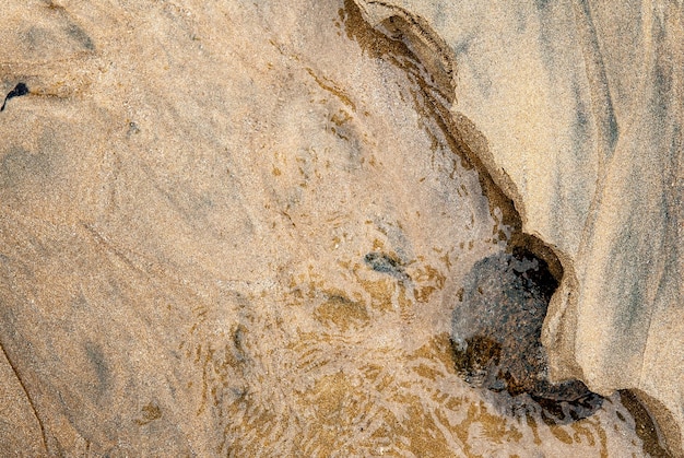 Spiel aus Material und Reflexionen, das durch den Sand und das Wasser eines Strandes in der Nordbretagne entsteht