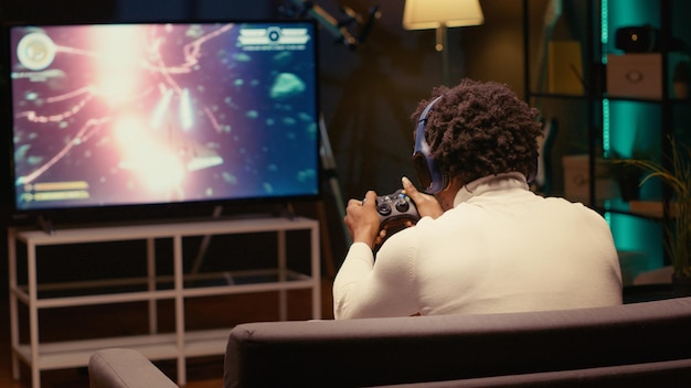 Spieler auf der Couch schreit wütend, nachdem ein fliegendes Raumschiff im Spiel zerstört wurde