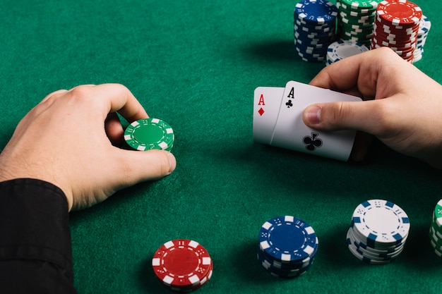 Spieler mit zwei Assen und Chips, die Poker spielen