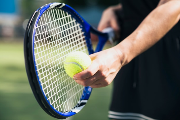 Foto spielerhand mit tennisball und schläger