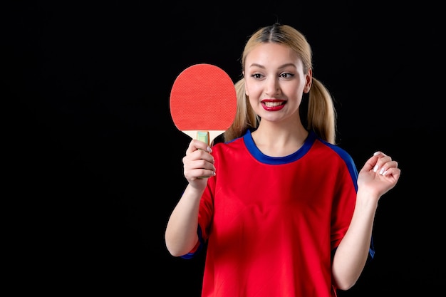 Spielerin mit Tischtennisschläger auf schwarzem Hintergrund Spiele spielen Sportler