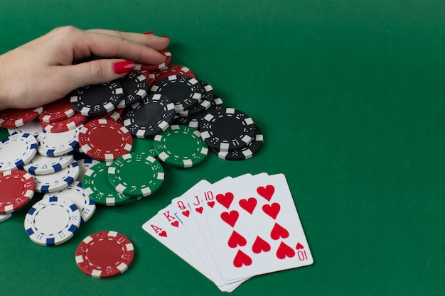 Spielkarten, Pokerchips und eine weibliche Hand