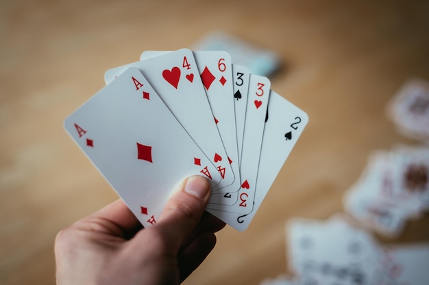 Foto spielkarten pokerkarten in der hand eines jungen mannes