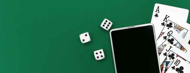 Spielkartenpokerwürfel und -telefon auf grünblauem Stoffpanorama