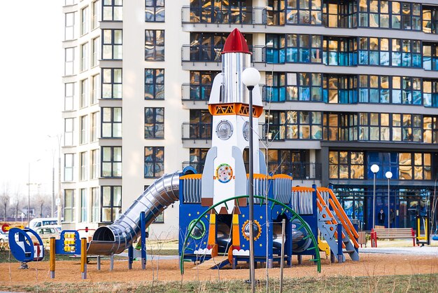 Spielplatz in Form einer Rakete in der Nähe der modernen Wolkenkratzerstadt