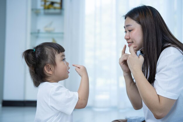 Spielzeit Nettes kleines Mädchen Vorschullernaktivitäten, die mit Mutter singen