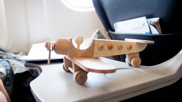 Spielzeug aus Holz Flugzeugfigur auf dem Tisch im modernen Jet-Flugzeug.