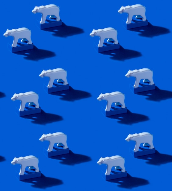 Spielzeug eisbären und blaue blöcke auf ozeanblauem hintergrund. nahtloses muster mit harten schatten. speichern sie das konzept der arktis und der globalen erwärmung
