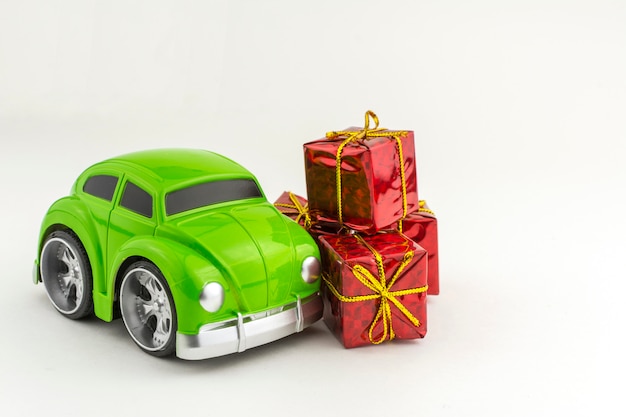 Spielzeug grünes Auto mit kleinen Geschenkboxen.