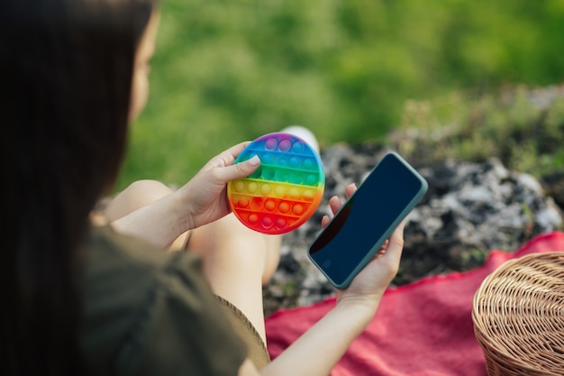 Spielzeug knall es und Telefon in den Händen des Mädchens