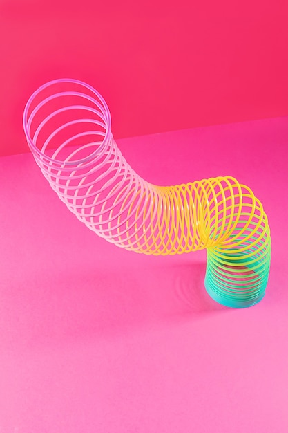 Spielzeug Plastik Regenbogen. Eine farbige Spirale für Spiel und Stunts, beliebt in den 90ern. Minimalismus. Das Konzept von Spielzeug, Kindheit. Helligkeit.