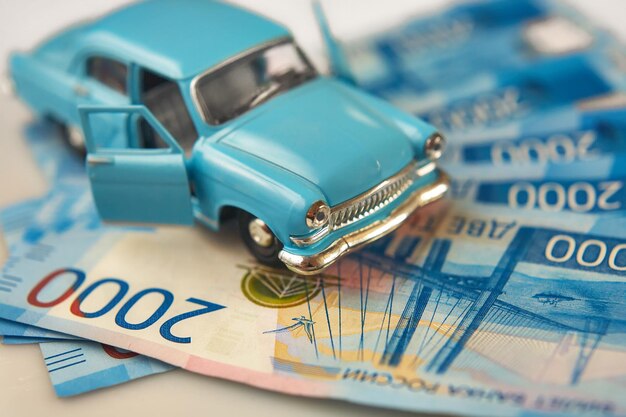 Spielzeug-Retro-Auto auf einem Hintergrund aus russischem Geld Das Konzept von c