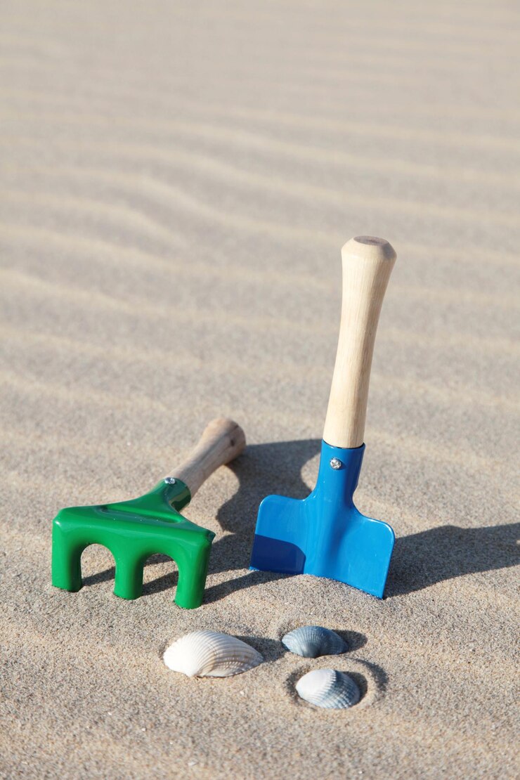 Foto spielzeug schaufel und rake am strand