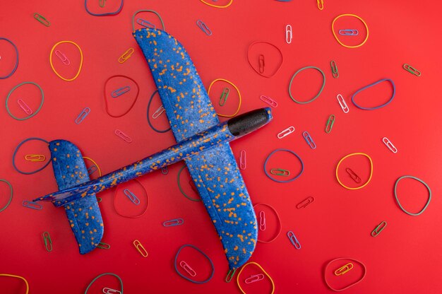 Spielzeug und Flugzeuge Blaues Flugzeug auf rotem Hintergrund Flugzeug und Muster Ansicht von oben