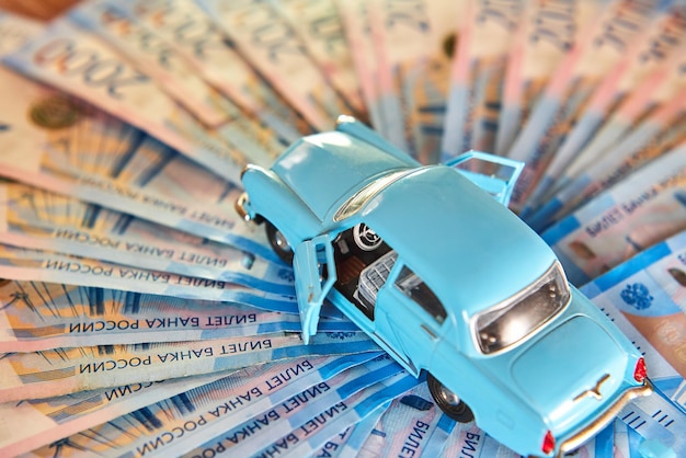 Spielzeugauto auf dem Hintergrund des russischen Geldes Konzept der Autoversicherung