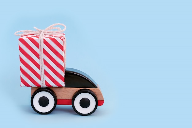 Foto spielzeugauto, das weihnachts- oder neujahrsgeschenk liefert. weihnachtsfeiertagsfeier und konzept des neuen jahres, kopienraum