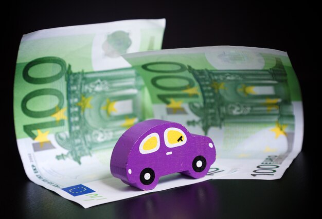 Spielzeugauto und Euro auf Schwarzem