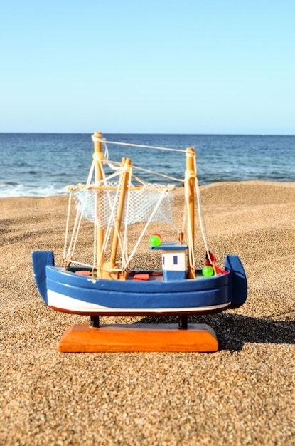 Spielzeugboot am Sandstrand